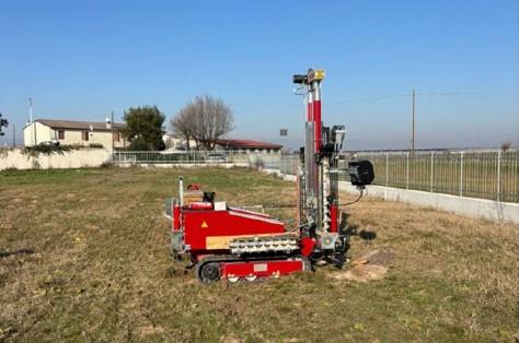 Penetrometro cingolato rosso su un prato con cielo sereno durante prove CPT e DPSH