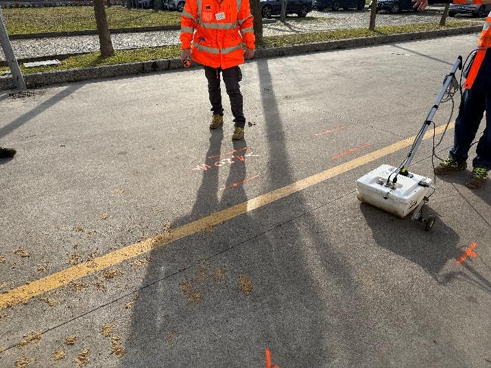 Georadar trascinato su un piazzale asfaltato da operatori con abbigliamento ad alta visibilità